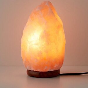 Himalayan salt lamp fitted with a sturdy wooden…